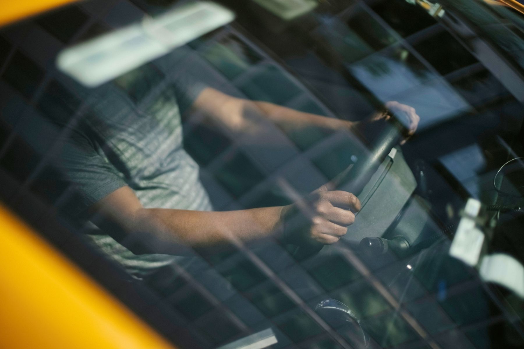 Person driving a car with hands on the steering wheel