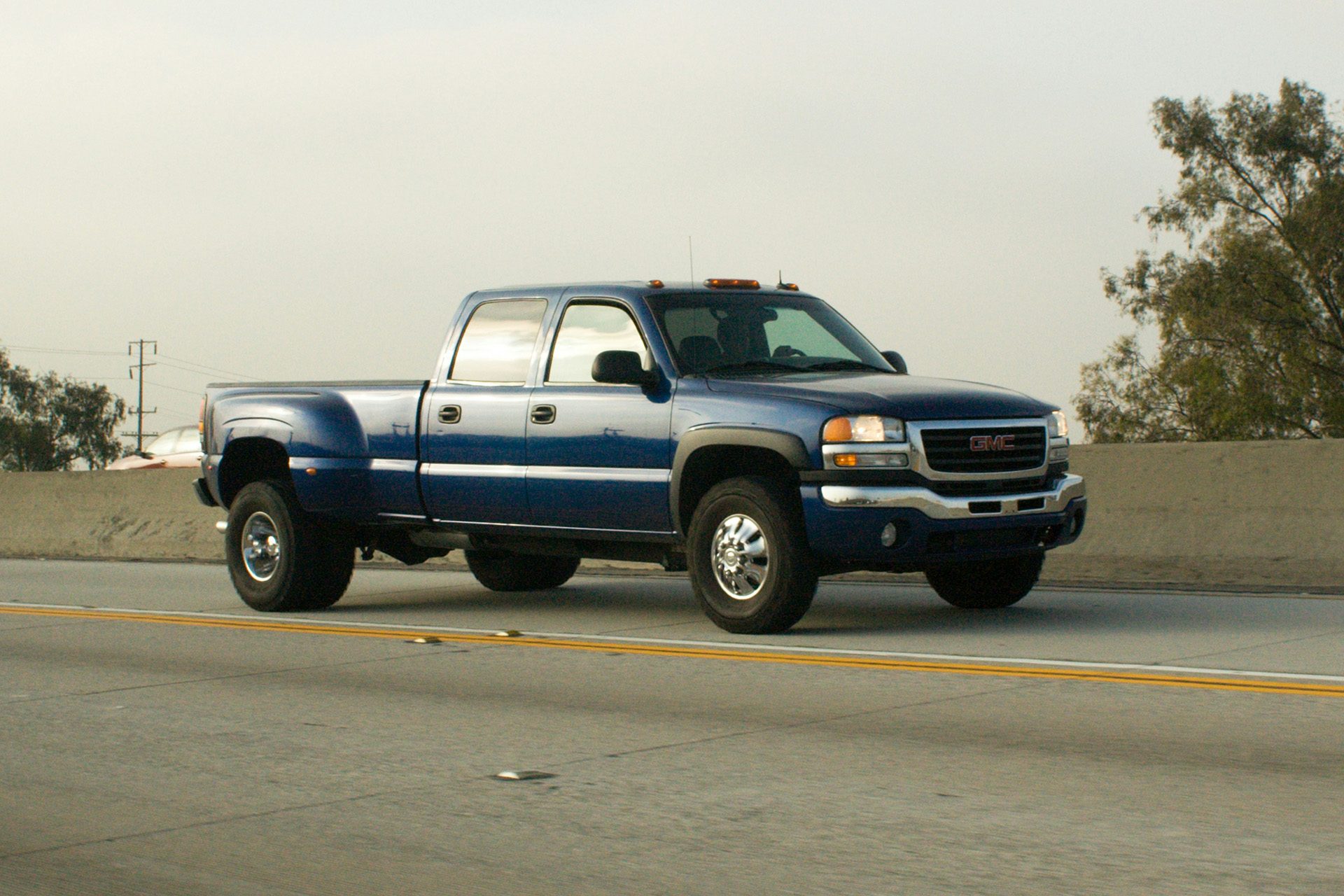 Blue GMC Sierra dually pickup truck driving on a California highway